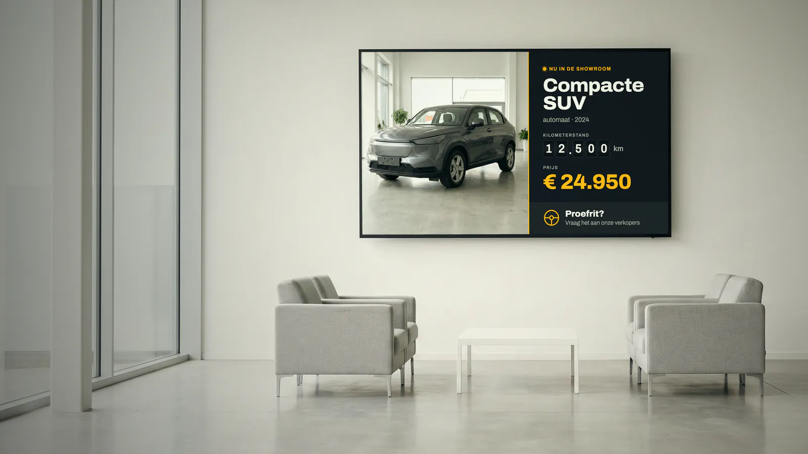 Lichte showroom met vier grijze fauteuils rond een lage witte tafel, grote ramen en een scherm met een compacte SUV en haar prijs