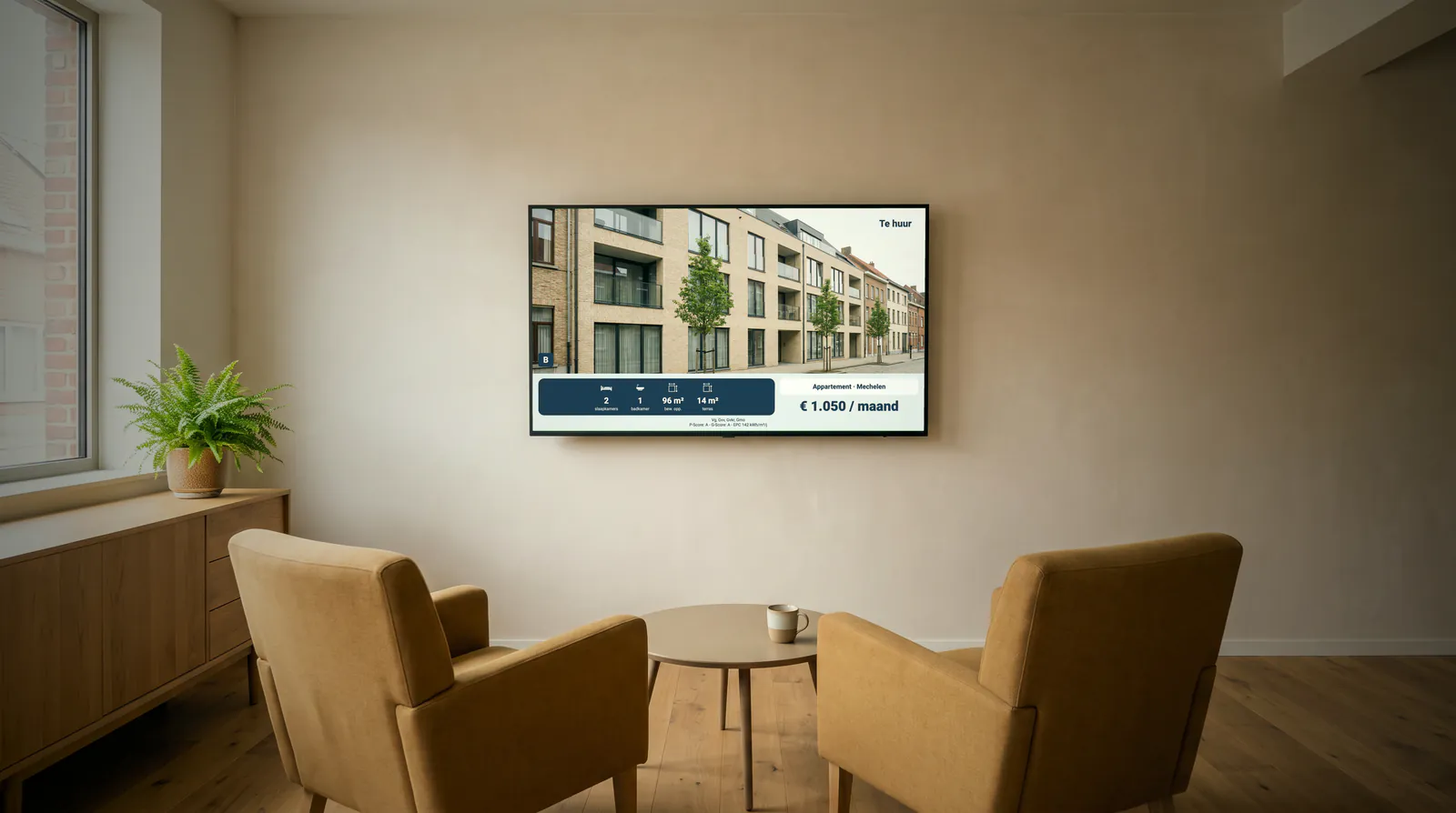 Waiting room of an estate agency with two armchairs around a coffee table, and on the wall a screen with a flat to let in Mechelen