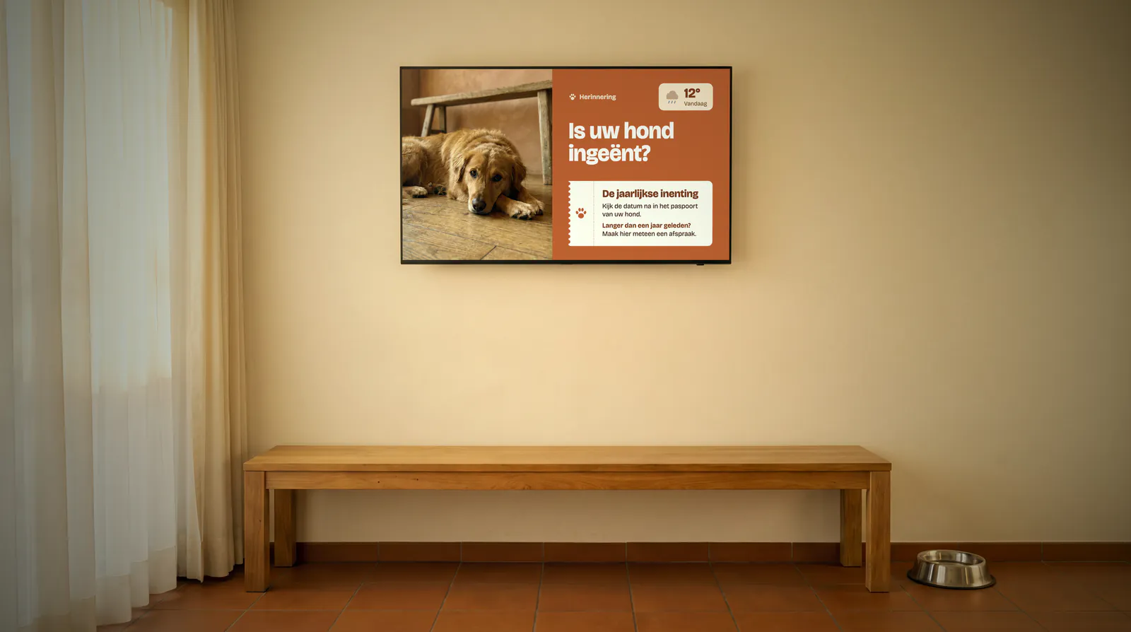 Waiting room of a veterinary practice with a long wooden bench, a water bowl on the tiled floor and a screen with a dog and a vaccination reminder